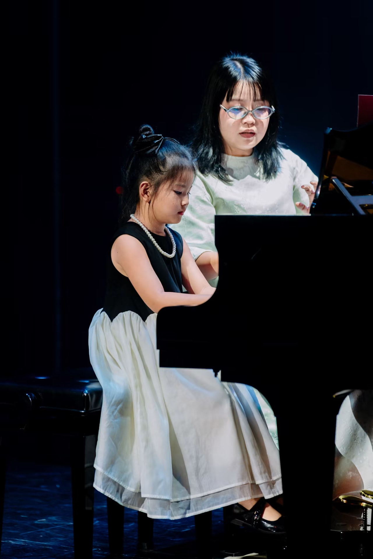 Giáo viên hướng dẫn học viên nhỏ biểu diễn Piano